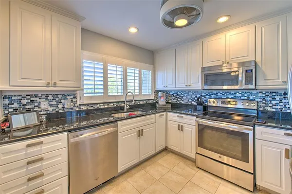 a kitchen with stainless steel appliances granite countertop a sink and a cabinets
