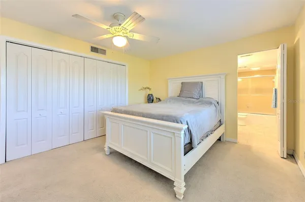 a spacious bedroom with a balcony a bed and a chandelier