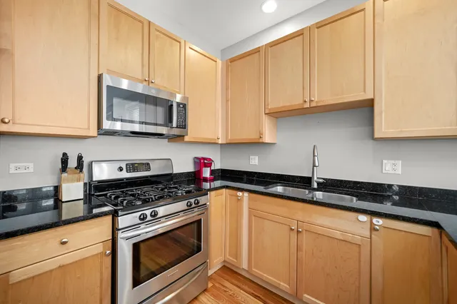 a kitchen with granite countertop white cabinets stainless steel appliances and a sink