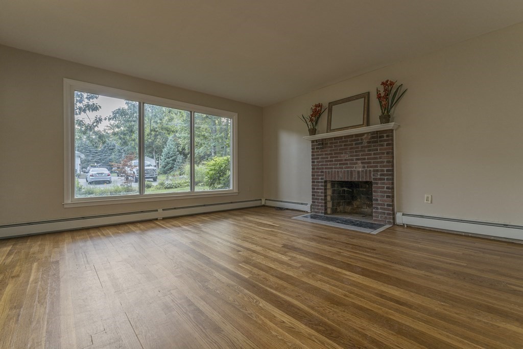 20 Laurelwood Road Rutland, MA 01543 - Photo 2 of 31 an empty room with wooden floor fireplace and windows