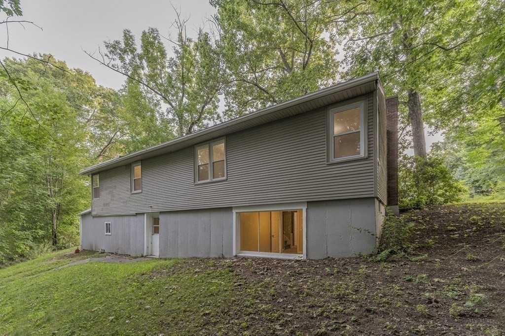 20 Laurelwood Road Rutland, MA 01543 - Photo 30 of 31 a brick house with a small yard plants and large trees