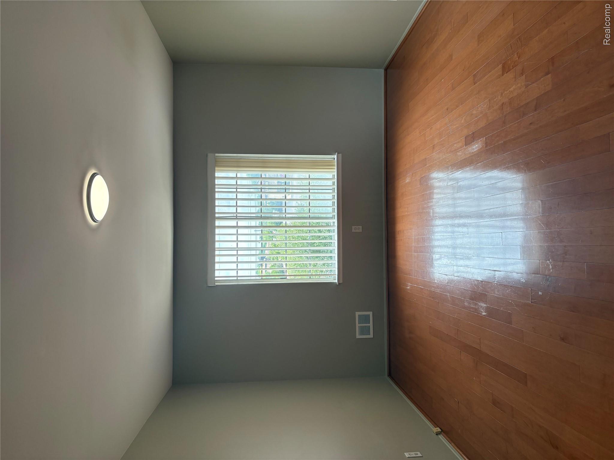 30200 Southfield Road Southfield, MI 48076 - Photo 9 of 14 Hardwood flooring, central ceiling light fixture, and window with vertical blinds
