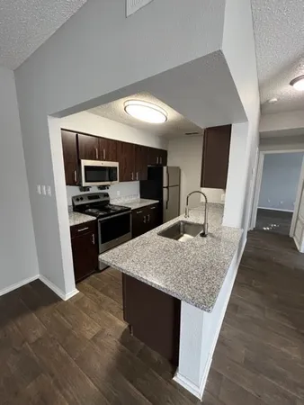 a kitchen with stainless steel appliances kitchen island granite countertop a stove and a sink