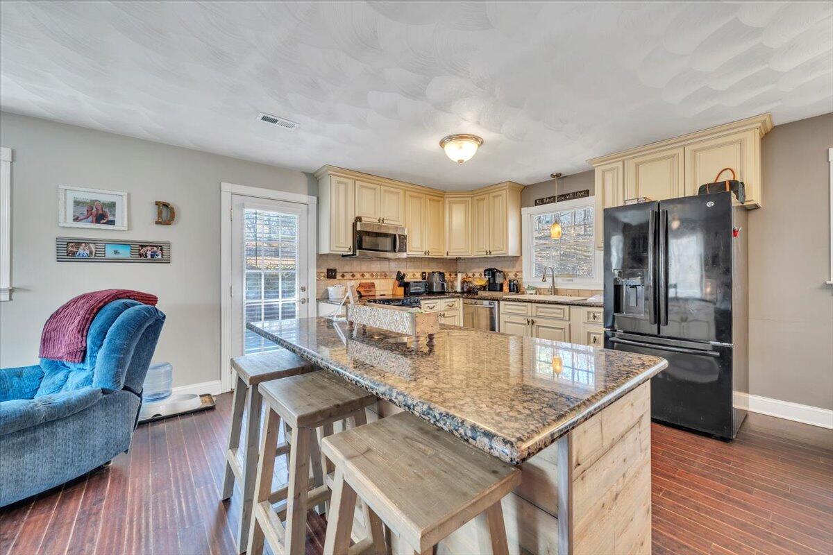 2166 Ruritan Road Roanoke, VA 24012 - Photo 11 of 46 a kitchen with stainless steel appliances granite countertop a stove refrigerator and a dining table with wooden floor