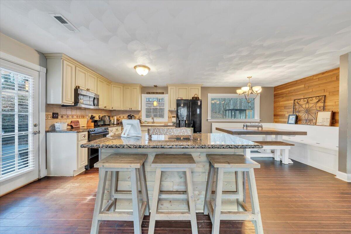 2166 Ruritan Road Roanoke, VA 24012 - Photo 10 of 46 a kitchen with stainless steel appliances granite countertop a stove top oven a sink dishwasher and white cabinets with wooden floor