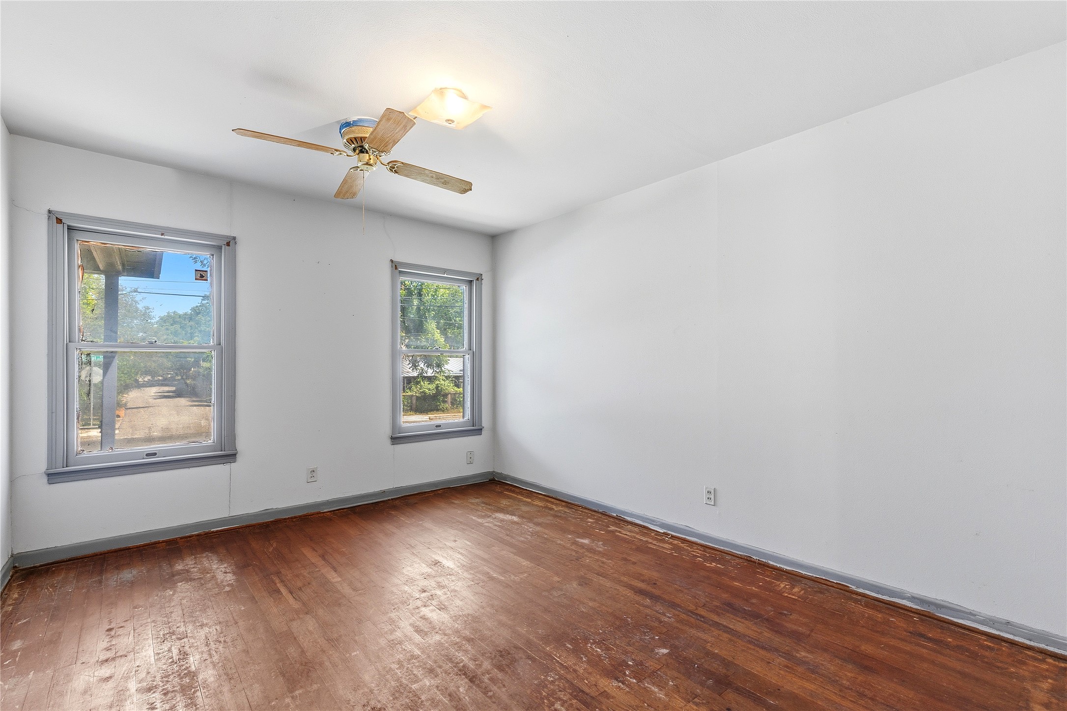 4900 Duval Street Austin, TX 78751 - Photo 17 of 25 One of three well sized bedrooms featuring original oak floors, original wood windows, and vintage trim details. The room reflects the home’s 1950s character and offers a strong starting point for restoration, refinishing, or thoughtful renovation.