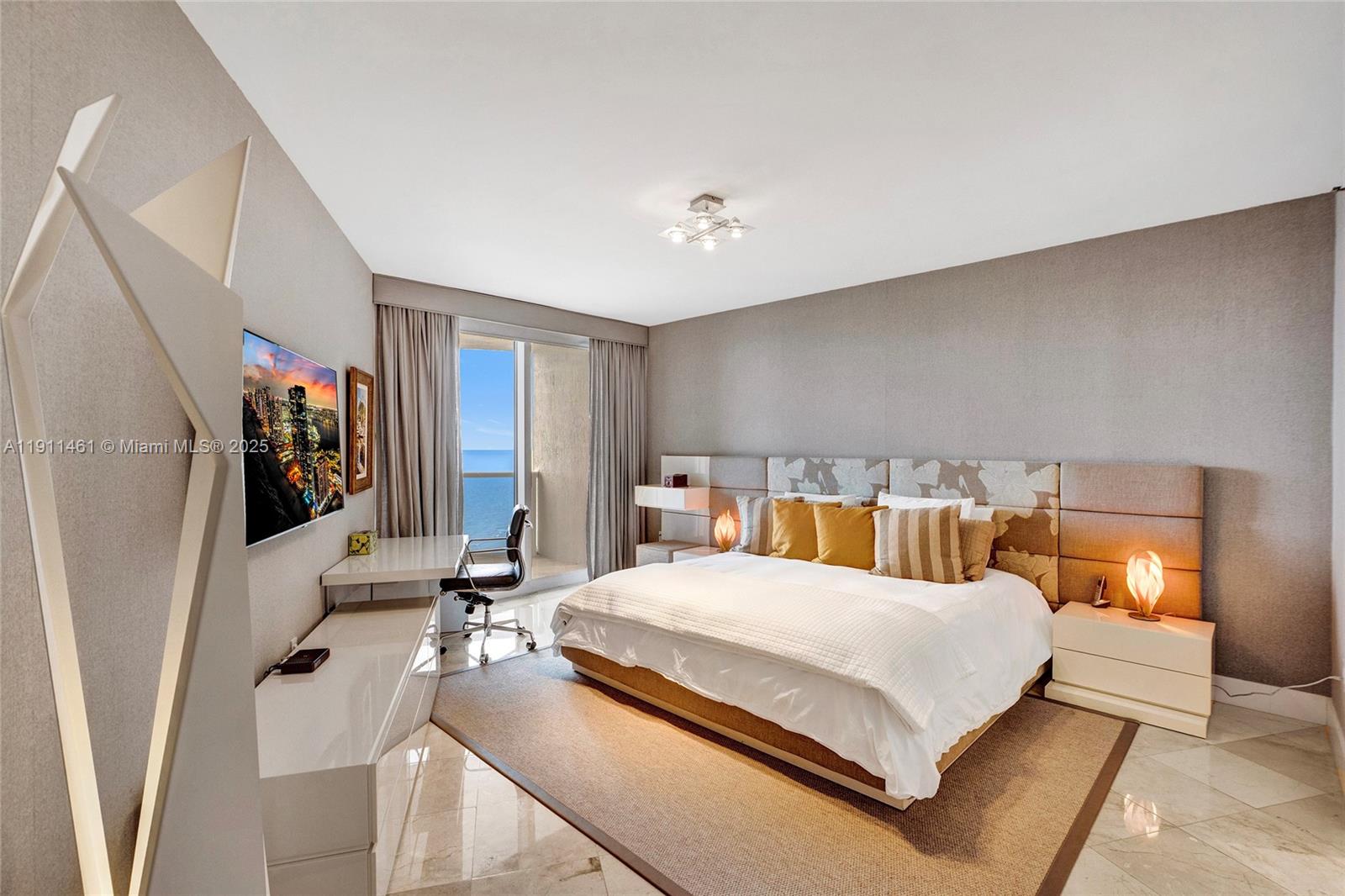 19111 Collins Avenue, Unit 1602 Sunny Isles Beach, FL 33160 - Photo 32 of 93 a bedroom with a large bed and a flat tv screen on the dresser