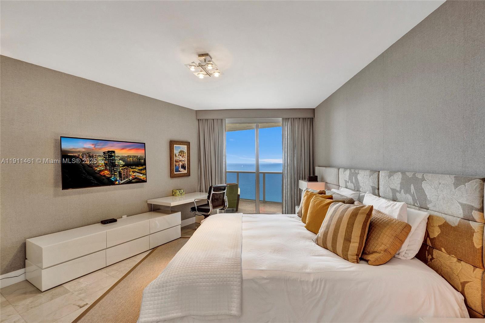 19111 Collins Avenue, Unit 1602 Sunny Isles Beach, FL 33160 - Photo 33 of 93 a bedroom with a large bed and a flat screen tv