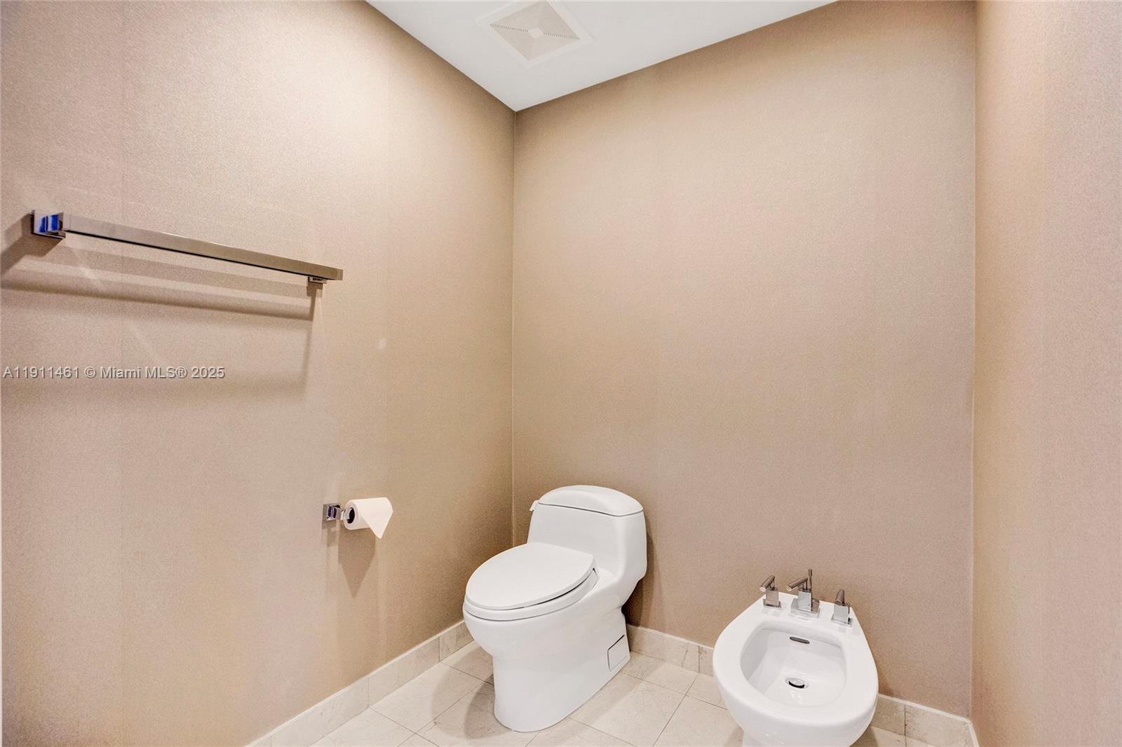 19111 Collins Avenue, Unit 1602 Sunny Isles Beach, FL 33160 - Photo 40 of 93 a white toilet sitting next to a white wall