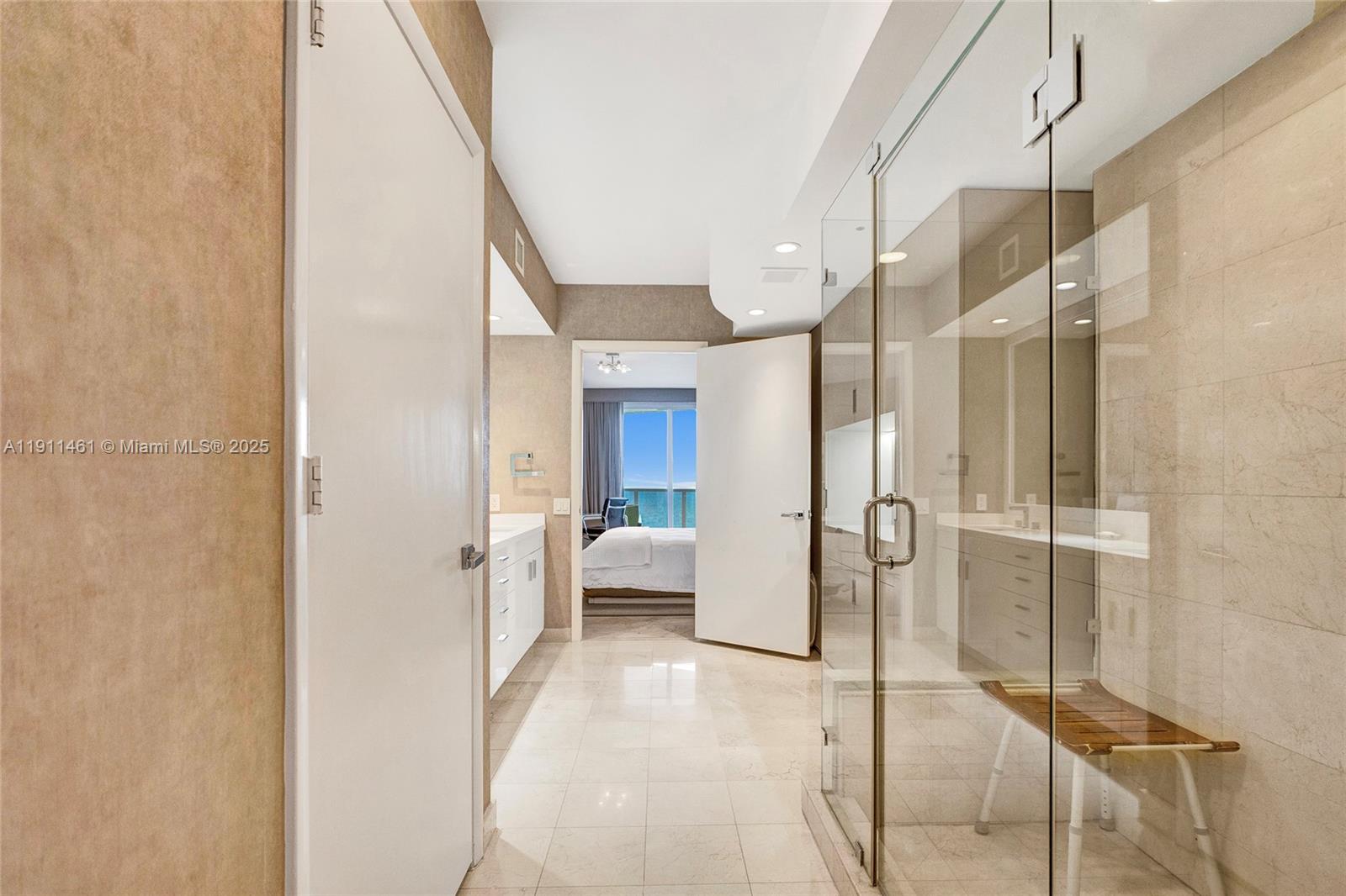19111 Collins Avenue, Unit 1602 Sunny Isles Beach, FL 33160 - Photo 41 of 93 a bathroom with a glass door shower and a sink