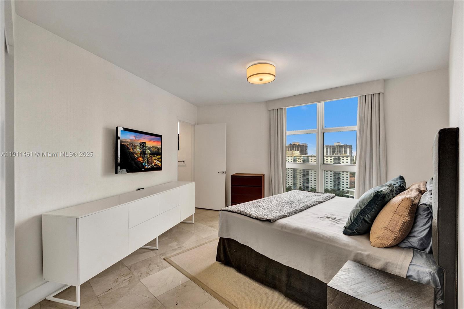 19111 Collins Avenue, Unit 1602 Sunny Isles Beach, FL 33160 - Photo 45 of 93 a living room with furniture and a flat screen tv