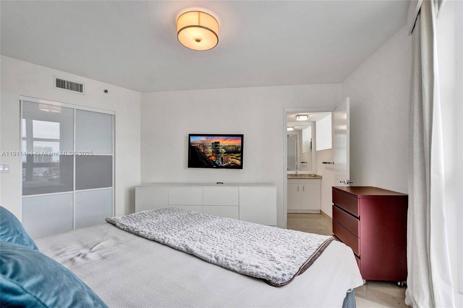 19111 Collins Avenue, Unit 1602 Sunny Isles Beach, FL 33160 - Photo 48 of 93 a bedroom with a bed and dresser