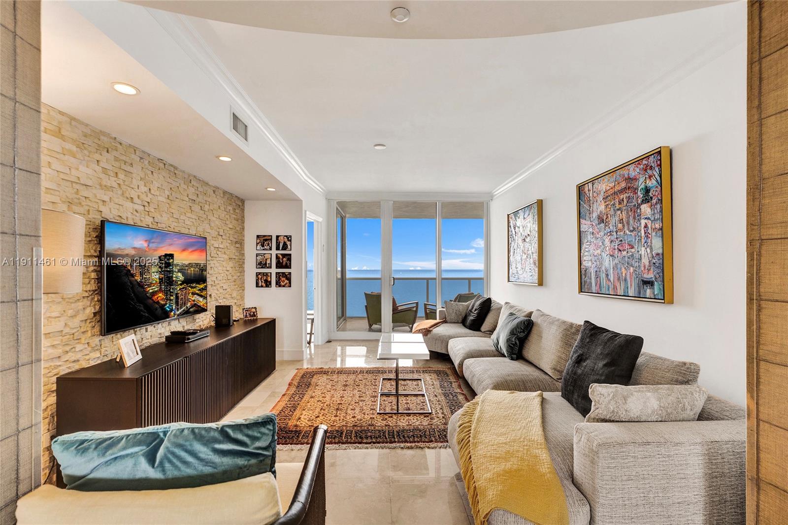 19111 Collins Avenue, Unit 1602 Sunny Isles Beach, FL 33160 - Photo 7 of 93 a living room with furniture and a flat screen tv