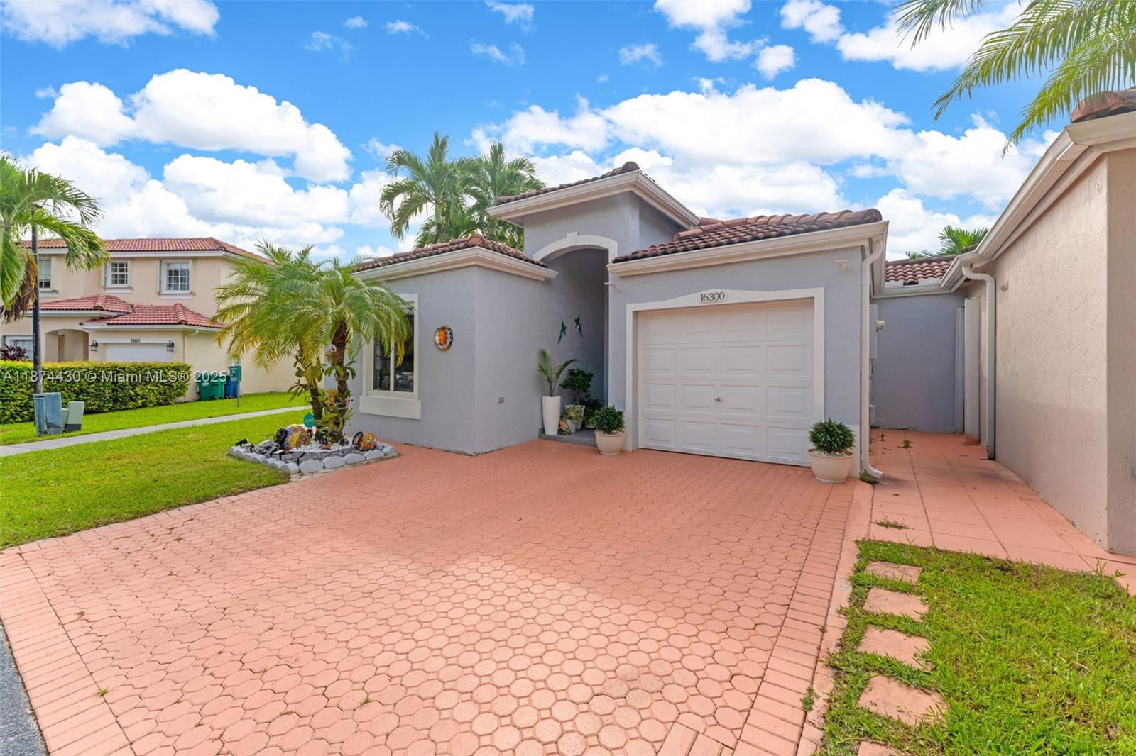 16300 Southwest 102nd Street Miami, FL 33196 - Photo 3 of 40 a front view of a house with a yard and garage