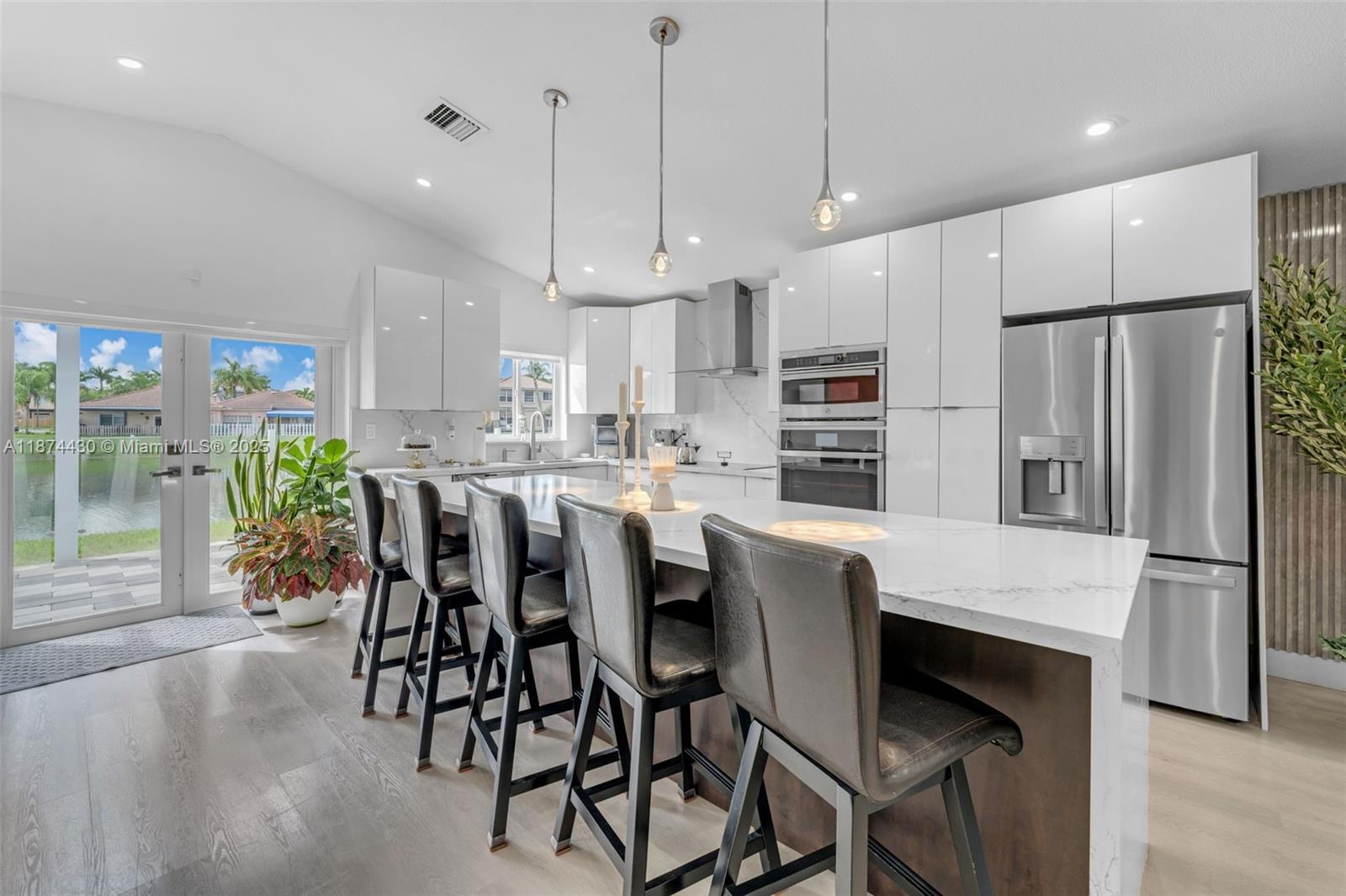16300 Southwest 102nd Street Miami, FL 33196 - Photo 7 of 40 a kitchen with kitchen island a dining table chairs stainless steel appliances and cabinets