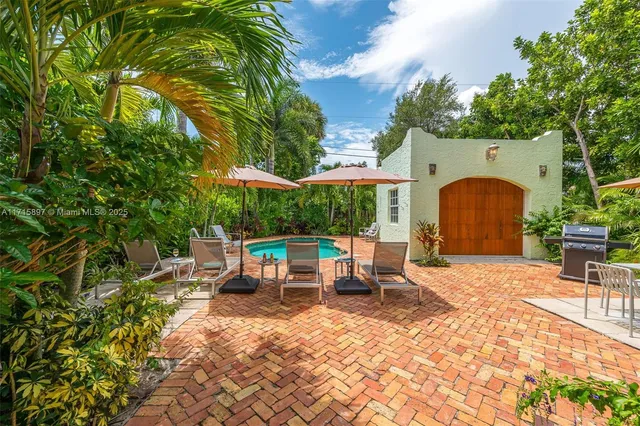 an aerial view of residential house with outdoor space and trees all around