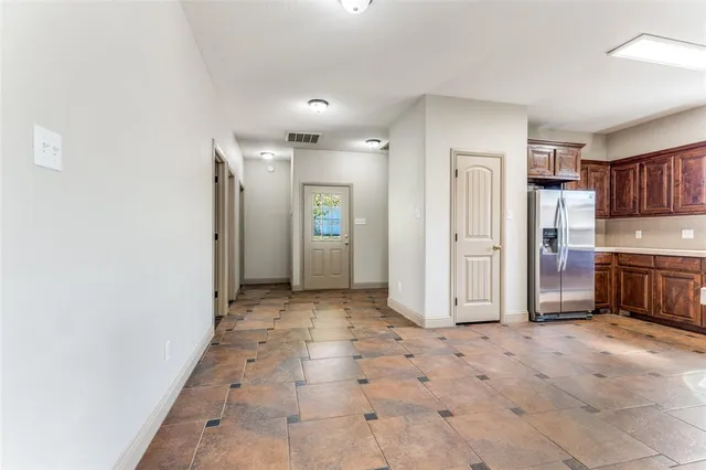 a kitchen with stainless steel appliances granite countertop a refrigerator and a stove top oven