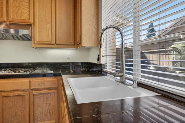 a kitchen with granite countertop a stove top oven and refrigerator
