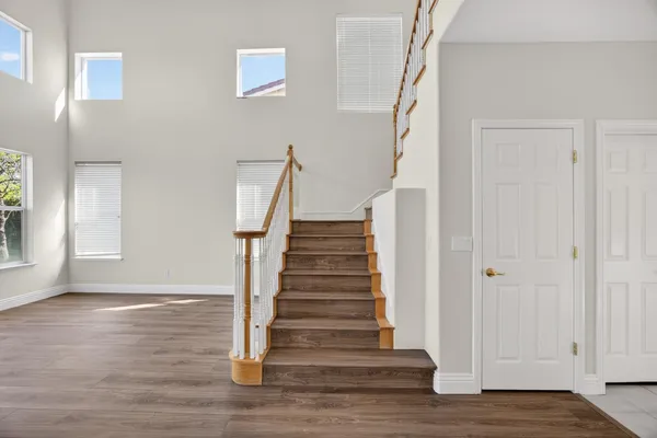 a large bedroom with a bed and wooden floor
