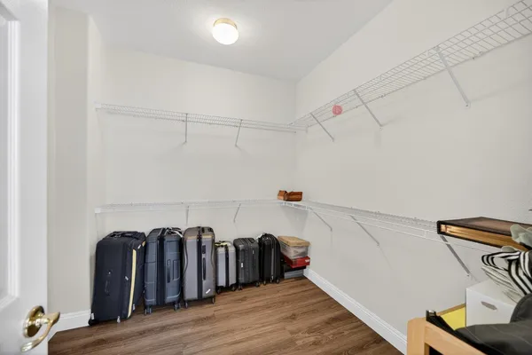 a view of a hallway with wooden floor staircase and a living room