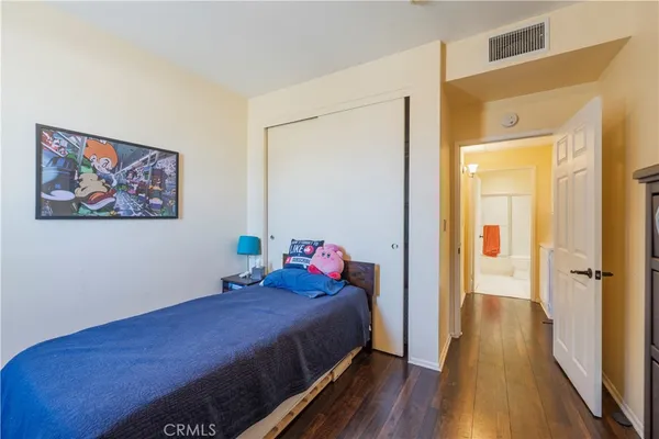 a bedroom with a bed and wooden floor