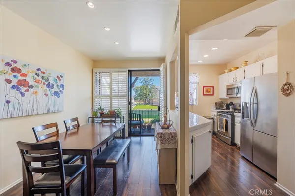 a view of a dining room with furniture a rug and wooden floor