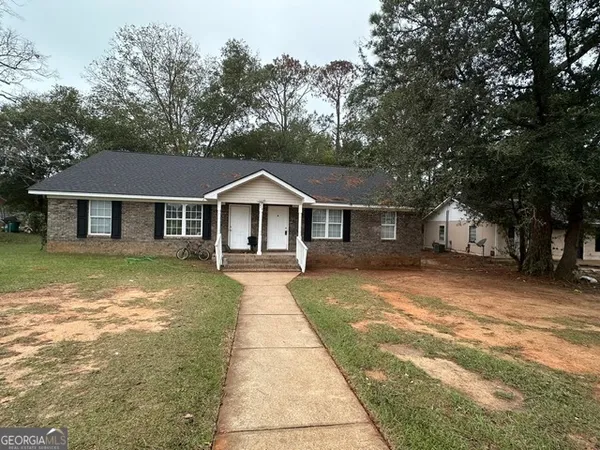 a front view of a house with yard patio and tree