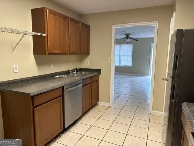 a kitchen with granite countertop a refrigerator stove and cabinets
