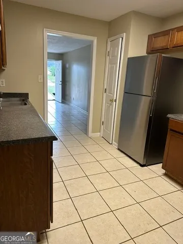 a kitchen with a refrigerator a stove top oven and cabinets