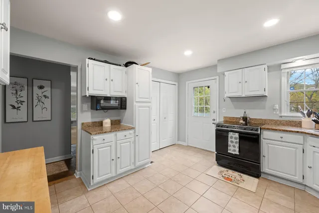 a kitchen with white cabinets and appliances