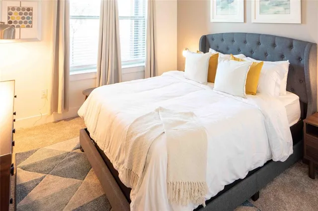 a bed sitting in a bedroom next to a window