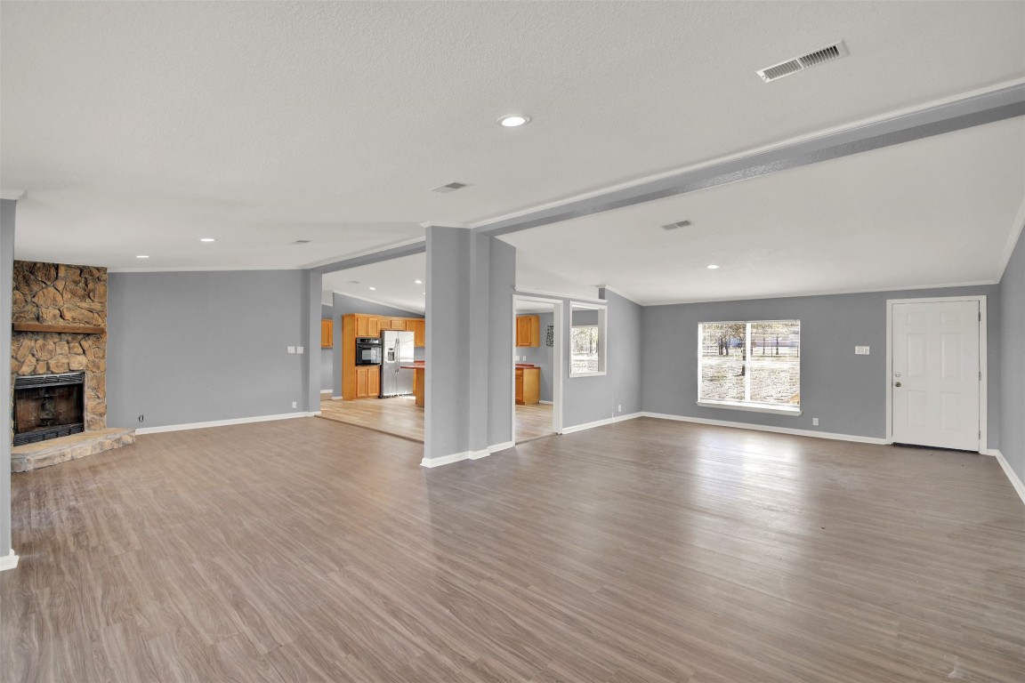 120 Webberwood Way Elgin, TX 78621 - Photo 12 of 36 Unfurnished living room with a stone fireplace, recessed lighting, and wood finished floors