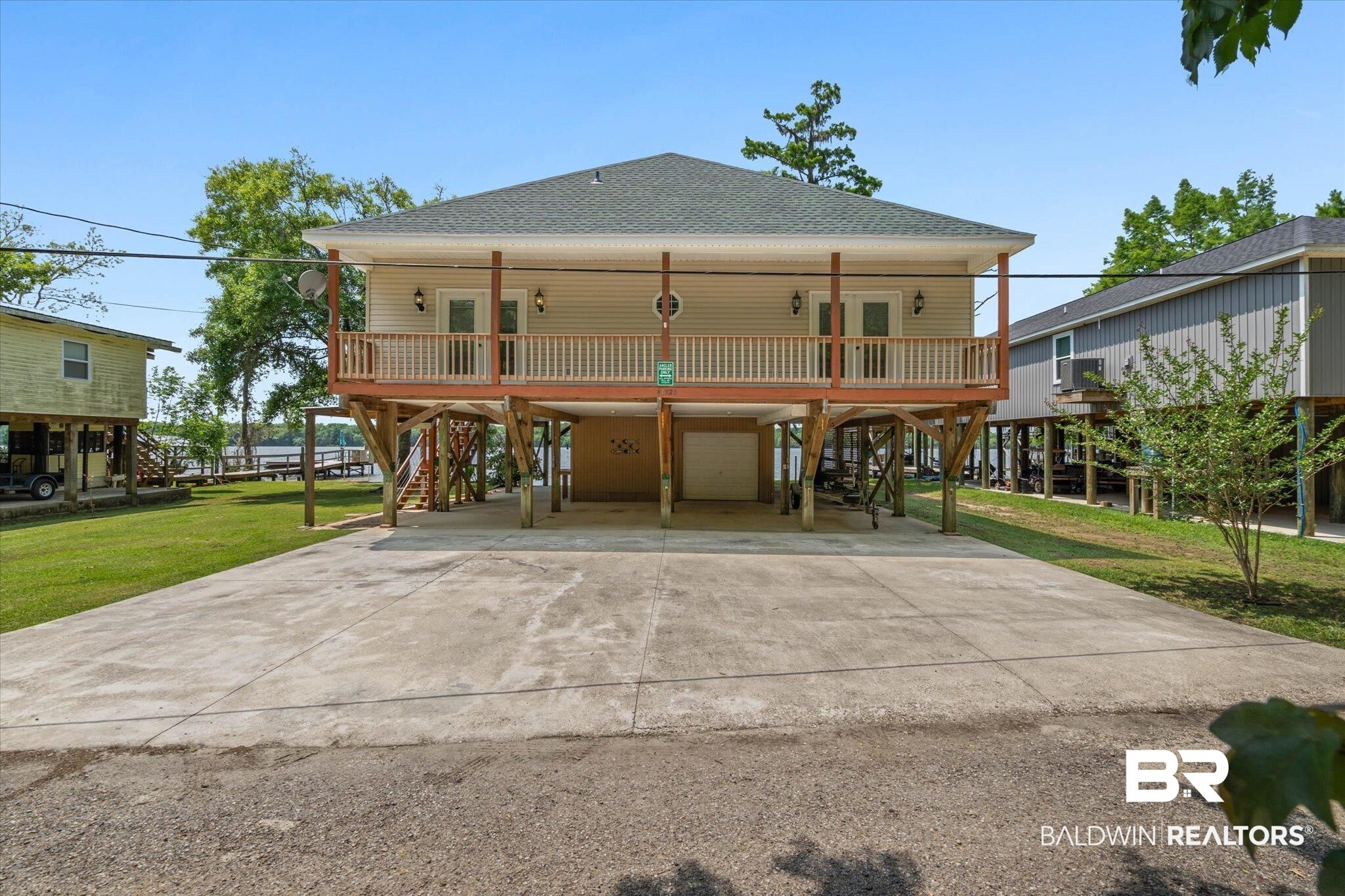 41923 Bayou Road Bay Minette, AL 36507 - Photo 30 of 35 Raised home featuring a full-width covered porch, elevated construction, a ground-level garage, and a concrete driveway