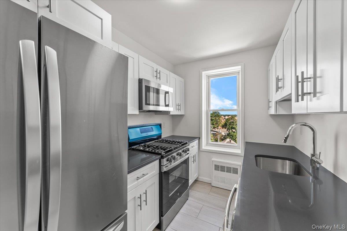 90 Union Street, Unit 6G New Rochelle, NY 10805 - Photo 12 of 20 a kitchen with stainless steel appliances granite countertop a refrigerator a stove a sink and a microwave with wooden floor