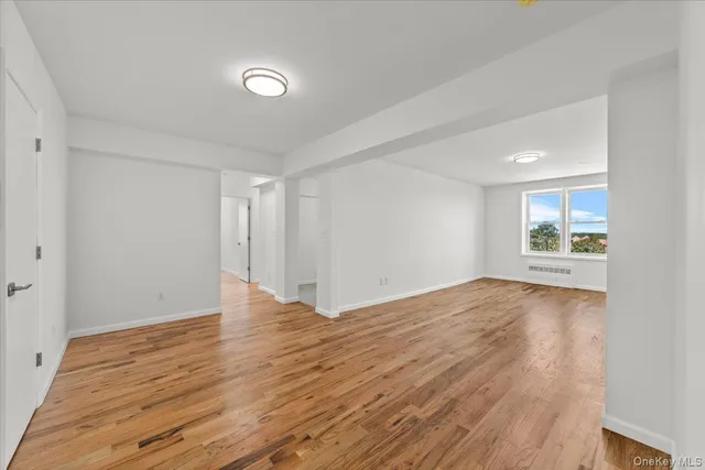 a view of a livingroom with wooden floor and a large window