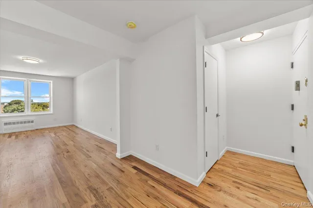 a view of a room with wooden floor and window