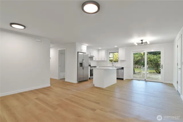 a view of a kitchen with furniture and wooden floor