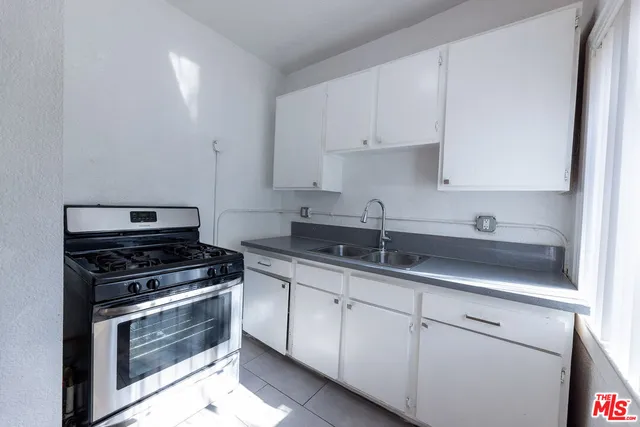 a kitchen with white cabinets and appliances