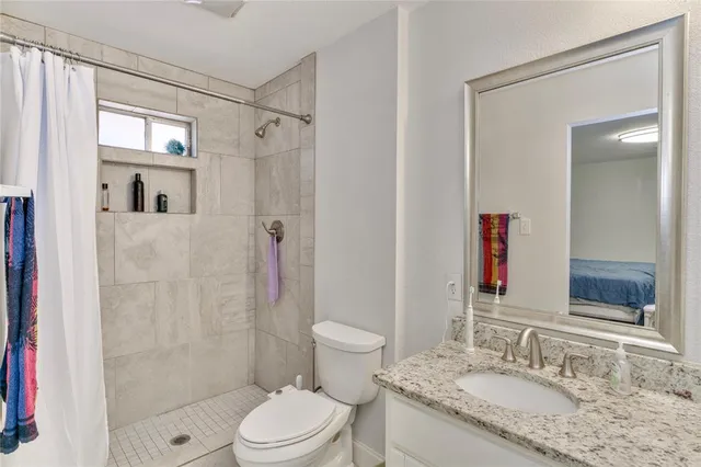 a bathroom with a granite countertop sink toilet and shower