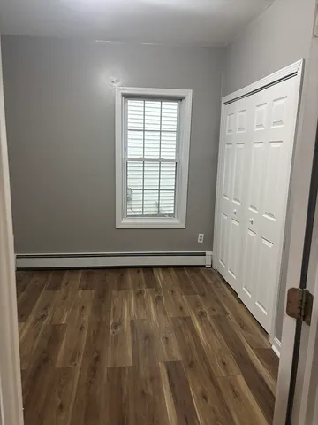a view of a room with wooden floor and window
