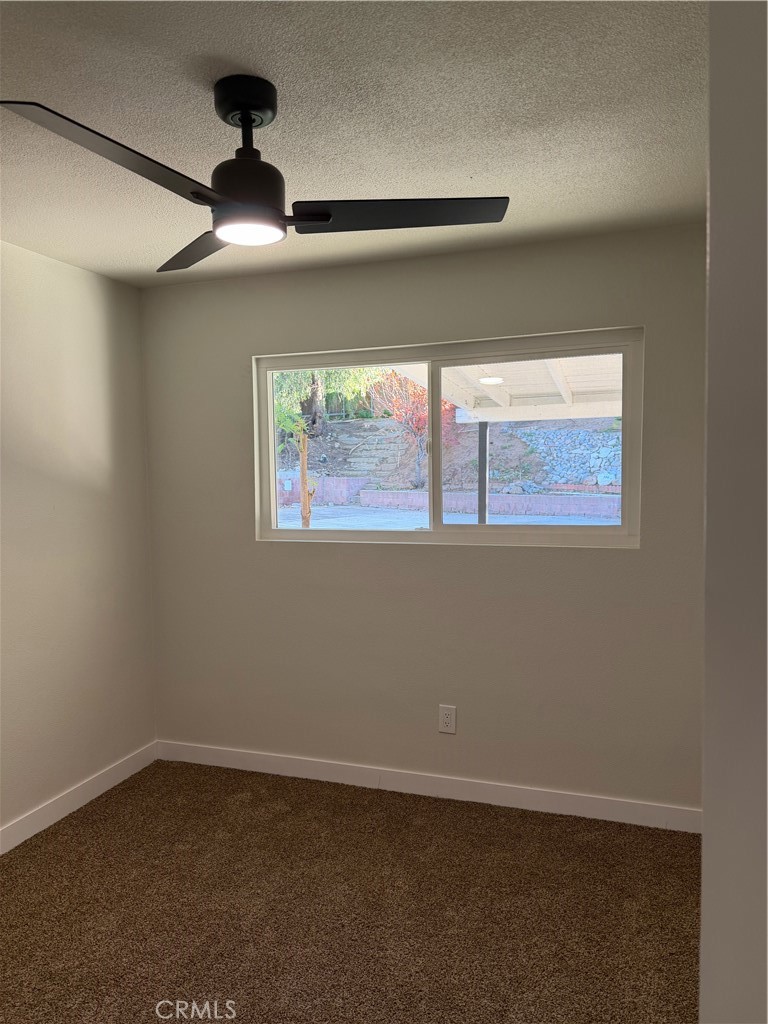 2579 Spring Meadow Lane Highland, CA 92346 - Photo 12 of 17 an empty room with a ceiling fan and a window