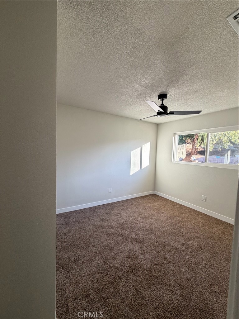 2579 Spring Meadow Lane Highland, CA 92346 - Photo 17 of 17 an empty room with windows and fan