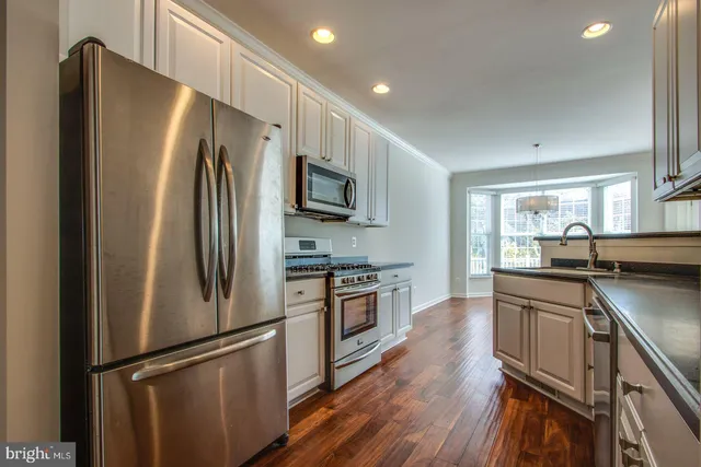 a kitchen with stainless steel appliances a refrigerator sink and microwave