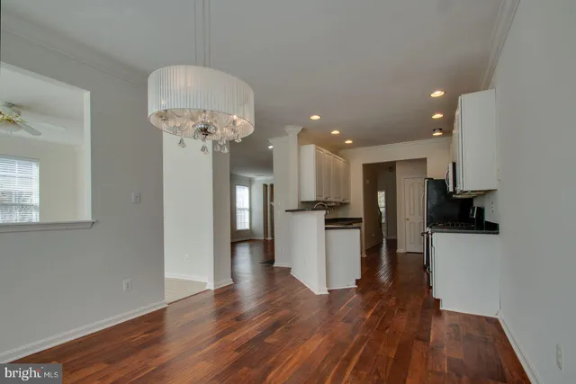 a view of a kitchen with refrigerator and wooden floor