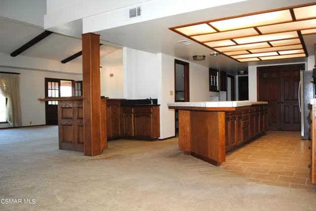 a view of kitchen with refrigerator cabinets and window