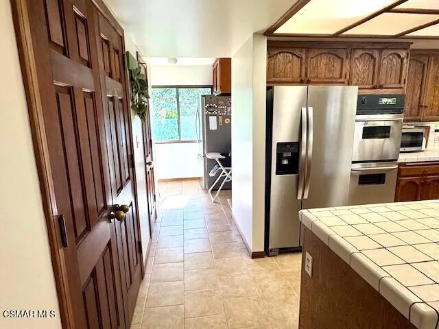 a kitchen with stainless steel appliances granite countertop a refrigerator and a stove top oven