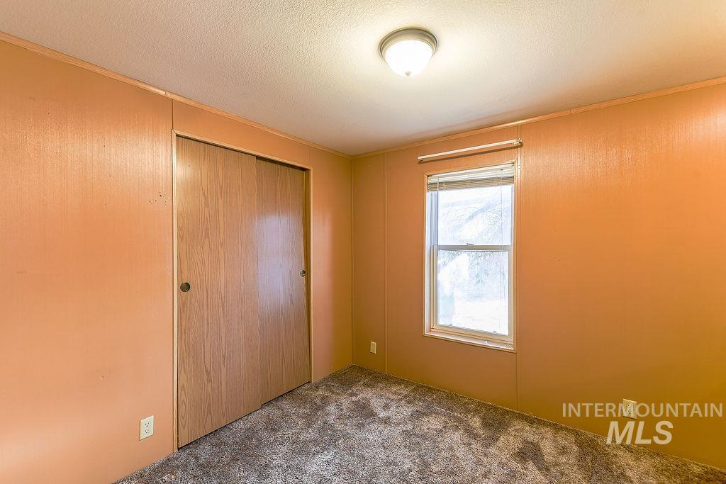 4325 Lenville Road, Unit 34 Moscow, ID 83843 - Photo 17 of 39 Unfurnished bedroom featuring carpet, a closet, and a textured ceiling