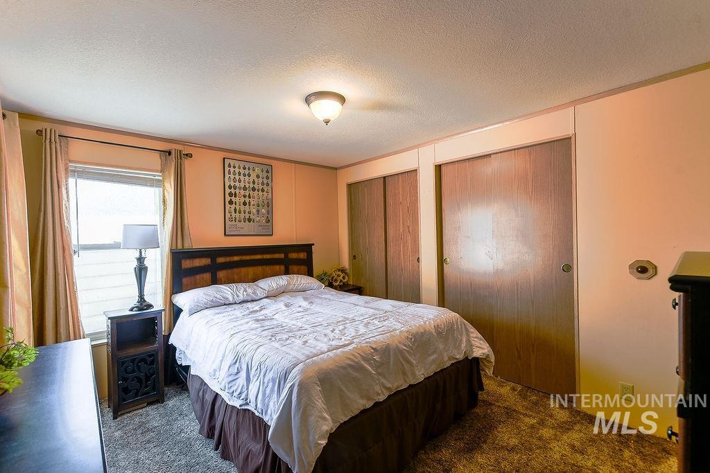 4325 Lenville Road, Unit 34 Moscow, ID 83843 - Photo 29 of 39 Carpeted bedroom featuring multiple closets and a textured ceiling