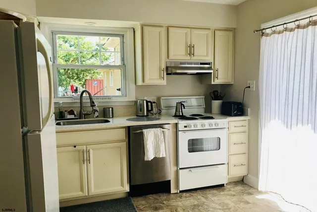 a kitchen with white cabinets and white appliances