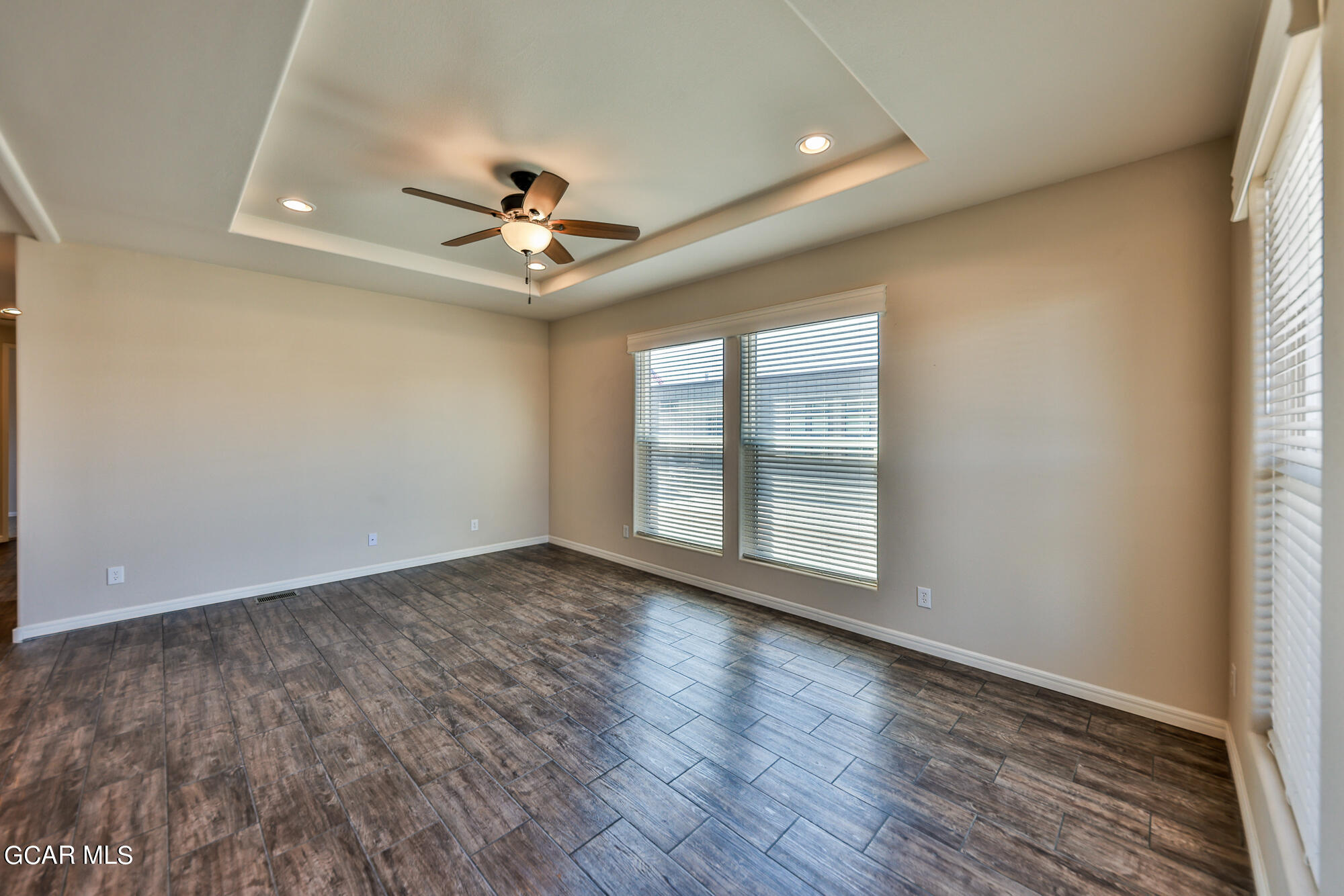 551 Summit Trail, Unit 145 Granby, CO 80446 - Photo 12 of 39 an empty room with wooden floor chandelier fan and windows